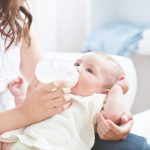 baby holding own bottle
