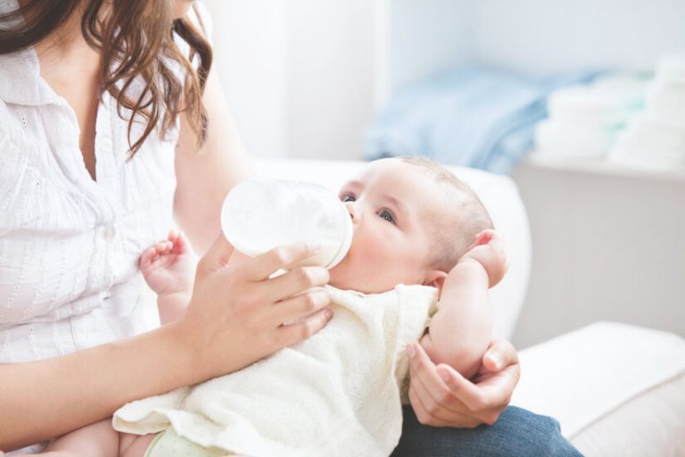 baby holding own bottle